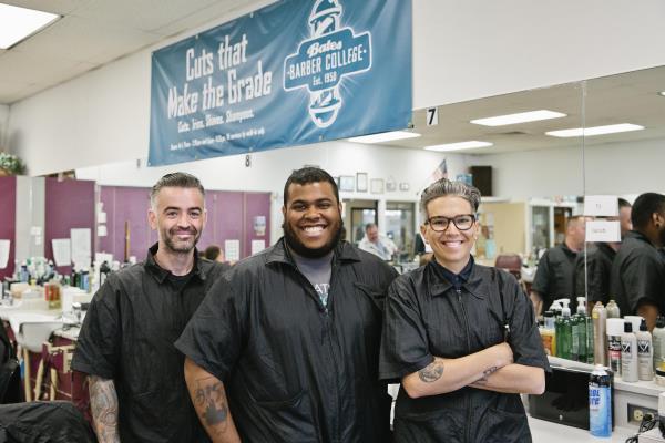 Three barber students smile in Barbershop